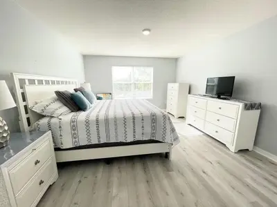 a bedroom with a bed and a dresser and a television at 4 Bed Private Yard-Pool Home in Kissimmee