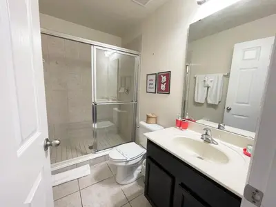 a bathroom with a sink and a shower and a toilet at 4 Bed Private Yard-Pool Home in Kissimmee