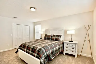 a bedroom with a bed and a table with a lamp at Private Heated Pool Water View Resort Fun Near Disney in Kissimmee