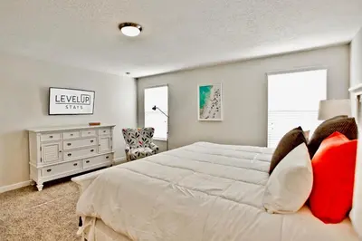 a bedroom with a large white bed with red pillows at Private Heated Pool Water View Resort Fun Near Disney in Kissimmee