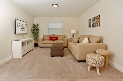 a living room with a couch and a chair at Private Heated Pool Water View Resort Fun Near Disney in Kissimmee