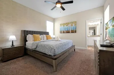 a bedroom with a bed and a ceiling fan at Family Pool Villa I Near Disney I 2 Free Clubhouses in Kissimmee