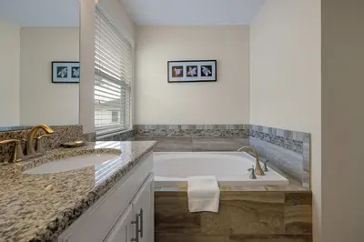 a bathroom with two sinks and a bath tub at Family Pool Villa I Near Disney I 2 Free Clubhouses in Kissimmee