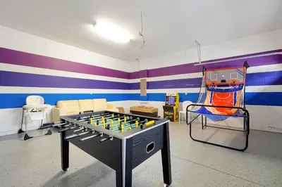 a room with a ping pong table and a couch at Magical Getaway Near Disney I Pool and Fun Room in Orlando