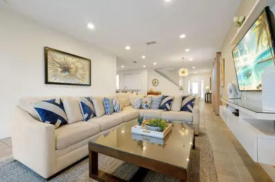 a living room with a white couch and a coffee table at Magical Getaway Near Disney I Pool and Fun Room in Orlando