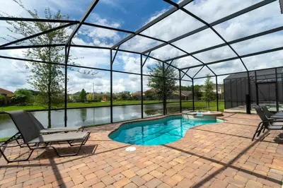 a swimming pool in a glass house with a patio at Casa Familiar c/ Piscina 9 Quartos Perto Disney in Kissimmee