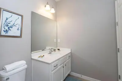 a white bathroom with a sink and a mirror at Casa Familiar c/ Piscina 9 Quartos Perto Disney in Kissimmee
