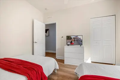 a bedroom with two beds and a flat screen tv at Townhome 4Q/3B perto da Disney -Lucaya Village in Kissimmee