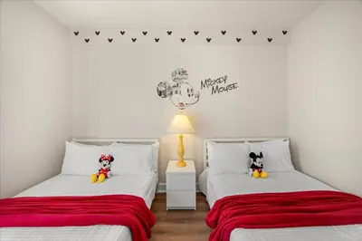 two beds in a white room with red sheets at Townhome 4Q/3B perto da Disney -Lucaya Village in Kissimmee