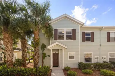 a house with palm trees in front of it at Townhome 4Q/3B perto da Disney -Lucaya Village in Kissimmee