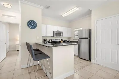 a kitchen with a counter and a clock on the wall at Townhome 4Q/3B perto da Disney -Lucaya Village in Kissimmee