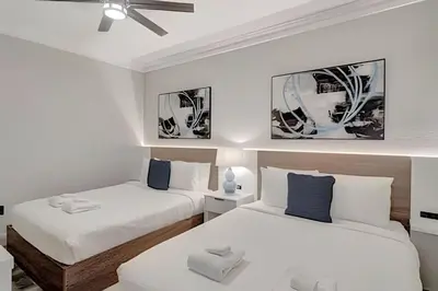 two beds in a room with white and blue at Luxo no Vista Cay | 4 quartos perto da Universal in Orlando