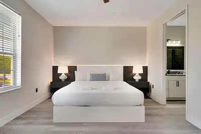 a white bedroom with a white bed and two lamps at Luxo no Vista Cay | 4 quartos perto da Universal in Orlando