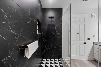 a bathroom with black marble walls and a shower at Luxo no Vista Cay | 4 quartos perto da Universal in Orlando