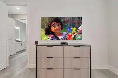 a flat screen tv sitting on top of a dresser in a room at Luxo no Vista Cay | 4 quartos perto da Universal in Orlando