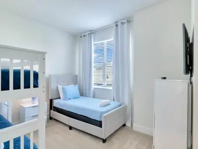 a white bedroom with a bed and a refrigerator at TR17226BD - 4 bedr w/pool - 10 guests Near Disney in Orlando
