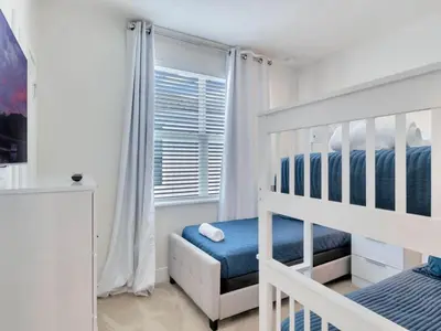 a white bedroom with a bunk bed and a window at TR17226BD - 4 bedr w/pool - 10 guests Near Disney in Orlando