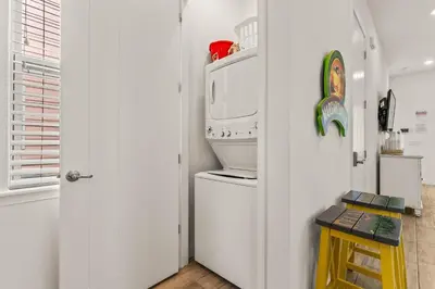 a kitchen with a washer and dryer on top of a refrigerator at Savannah Daydreamin - For 6 in Orlando
