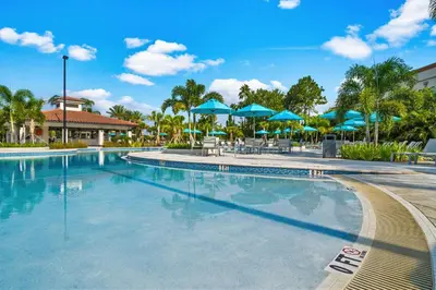 a swimming pool at a resort with blue umbrellas at Seaescape in Orlando