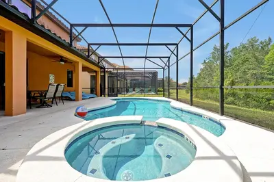 a large swimming pool in a building with a patio at 2616 TRANQUILITY KISSIMMEE 6 BED in Kissimmee