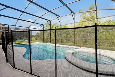 a batting cage with a swimming pool inside of it at 2616 TRANQUILITY KISSIMMEE 6 BED in Kissimmee