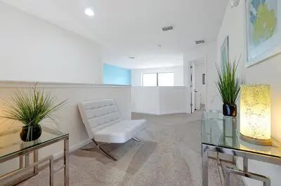 a living room with a white chair and a glass table at 2616 TRANQUILITY KISSIMMEE 6 BED in Kissimmee