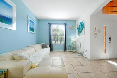 a living room with a white couch and blue walls at 2616 TRANQUILITY KISSIMMEE 6 BED in Kissimmee