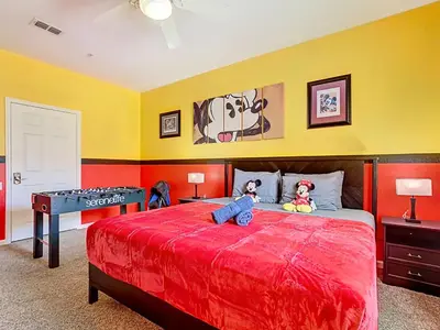 a bedroom with a bed with a red bedspread at Windsor Hills Magical Condo Pool Slides By Disney in Orlando