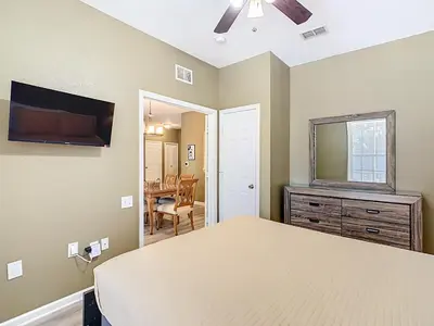 a bedroom with a bed and a television and a table at Windsor Hills 3BR - Mickey Themed Spacious Condo in Orlando