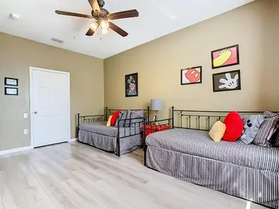 a living room with two beds and a ceiling fan at Windsor Hills 3BR - Mickey Themed Spacious Condo in Orlando