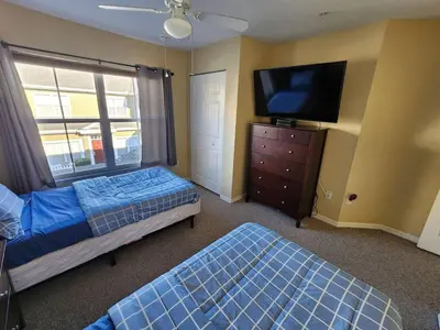 a bedroom with two beds and a flat screen tv at 3 Bedroom 2 Bathroom Villas At Seven Dwarfs 20-104 in Kissimmee