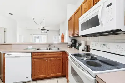 a kitchen with white appliances and wooden cabinets at Resort stay Pool Access Peaceful Retreat Balcony in Kissimmee