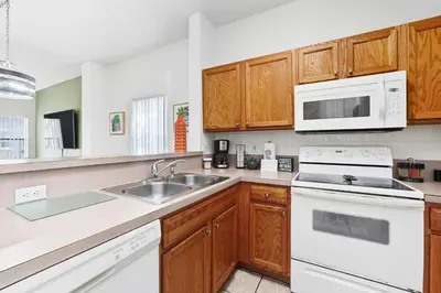 a kitchen with white appliances and wooden cabinets at Resort stay Pool Access Peaceful Retreat Balcony in Kissimmee