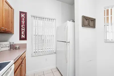 a kitchen with a white refrigerator and a window at Resort stay Pool Access Peaceful Retreat Balcony in Kissimmee