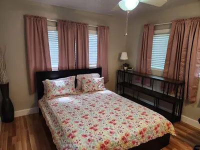 a bedroom with a bed with a floral bedspread at Sunny Retreat in Orlando