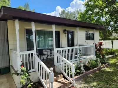 a small white house with a porch at Sunny Retreat in Orlando