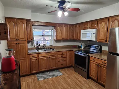 a kitchen with wooden cabinets and a ceiling fan at Sunny Retreat in Orlando