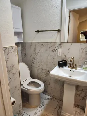 a bathroom with a toilet and a sink at Sunny Retreat in Orlando