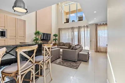 a kitchen and living room with a counter and chairs at Home Luxury 03 Beds Close Disney At Magic Village in Orlando