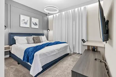 a bedroom with a blue bed and a flat screen tv at Amazing 05 Bedrooms At Storey Lake in Kissimmee