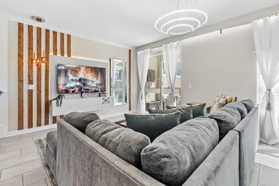 a living room with a large couch and a tv at Amazing 05 Bedrooms At Storey Lake in Kissimmee