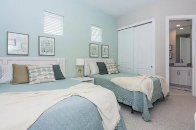 two beds in a bedroom with blue walls at Magic 5bd House 8 min from Disney in Orlando