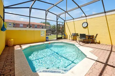 a swimming pool with a clock on the side of a building at 8567 BAY LILY LOOP 3 BED in Kissimmee