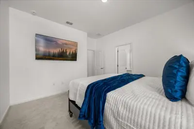 a bedroom with a bed with a blue blanket on it at 15 Bedrooms15 Bathrooms Veranda Palms 2393Sd in Kissimmee