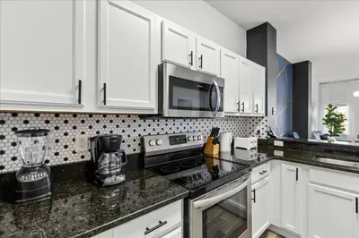 a kitchen with white cabinets and black counter tops at 3 Bedrooms 3 Bathrooms Encantada Resort 3097Yl in Kissimmee