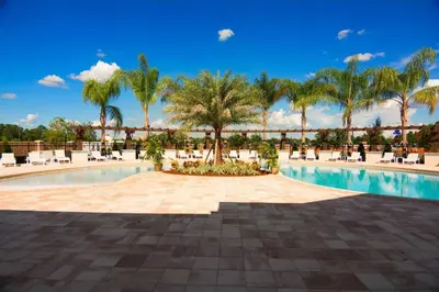 a pool at a resort with palm trees and chairs at TVPM-3230WA in Kissimmee