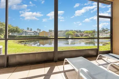a room with windows looking out at a lake at 8702 PAPAYA DR 2BED in Kissimmee