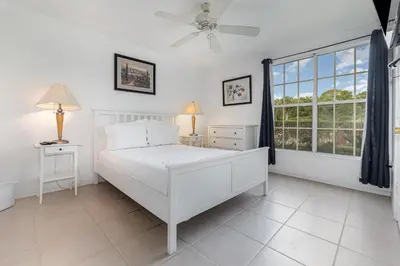 a white bedroom with a bed and a window at 8702 PAPAYA DR 2BED in Kissimmee