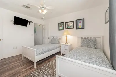 a bedroom with two beds and a tv at 8702 PAPAYA DR 2BED in Kissimmee