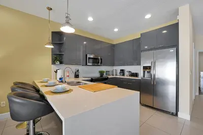a kitchen with black cabinets and a counter with a refrigerator at 1617 Retreat Circle Clermont 3 BED in Orlando